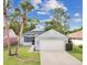 Inviting home with a manicured lawn, palm trees and attached two-car garage at 432 Sandestin Dr, Winter Haven, FL 33884