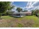 Spacious backyard with a screened-in pool surrounded by a well-maintained lawn at 4825 Luce Rd, Lakeland, FL 33813