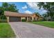 Charming brick home with a well-kept lawn and a brick driveway leading to a two-car garage at 4825 Luce Rd, Lakeland, FL 33813