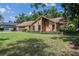 Traditional brick home with a lush green lawn and mature trees offering shade at 4825 Luce Rd, Lakeland, FL 33813