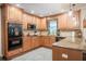 A beautifully arranged kitchen with wood cabinets, granite countertops, and black appliances at 4825 Luce Rd, Lakeland, FL 33813