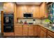 A well-lit kitchen with wood cabinets, black appliances, granite countertops, and decor at 4825 Luce Rd, Lakeland, FL 33813