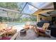 Relaxing screened-in pool area with Adirondack chairs, fire pit, and an outdoor grill at 4825 Luce Rd, Lakeland, FL 33813