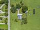 An aerial view features a home with a lush green lawn, mature trees, and a neighboring shed at 511 Hickory Hammock Rd, Lake Wales, FL 33859