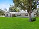 Inviting home exterior with lush green lawn and mature shade tree, creating a serene setting at 511 Hickory Hammock Rd, Lake Wales, FL 33859