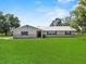Charming single-story home with a well-manicured lawn and a classic, neutral-toned facade at 511 Hickory Hammock Rd, Lake Wales, FL 33859