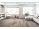 Bright living room featuring vinyl plank flooring, large windows, and modern furnishings at 5418 Duxford Cir, St Cloud, FL 34771
