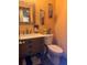 Stylish half bathroom with rustic vanity, framed mirror, and decorative sconces at 5619 Antler Trl, Lakeland, FL 33811