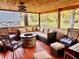 This screened patio area has a wood ceiling and features a stone fireplace surrounded by chairs and a sectional at 5619 Antler Trl, Lakeland, FL 33811