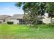 Backyard showcasing lush lawn, mature trees, and a screened-in lanai, perfect for outdoor relaxation at 6086 Swallow Dr, Lakeland, FL 33809