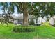 Beautifully landscaped backyard featuring lush greenery and a mature shade tree, adjacent to screened porch at 6086 Swallow Dr, Lakeland, FL 33809