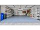 Spacious garage with ample storage shelving, painted floors, and lots of room for parking and projects at 6086 Swallow Dr, Lakeland, FL 33809