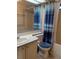 Functional bathroom featuring a vanity with sink, toilet, and shower with blue curtain and patterned details at 612 Forest Lake Dr, Lakeland, FL 33809