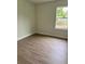 This bedroom has wood-look flooring, neutral paint, and a bright window at 625 W 9Th St, Lakeland, FL 33805