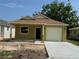 Lovely one-story house with a front-facing garage, neutral color palette, and a neatly laid concrete driveway at 625 W 9Th St, Lakeland, FL 33805