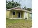 Quaint single-Gathering home with a light yellow exterior, a small lawn, and a one-car garage at 625 W 9Th St, Lakeland, FL 33805