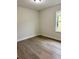 A bedroom with hardwood flooring, neutral paint, modern baseboards, and natural light from a window at 629 W 9Th, Lakeland, FL 33805