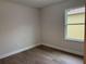 A bedroom with hardwood flooring, neutral paint, modern baseboards, and a window view at 629 W 9Th, Lakeland, FL 33805
