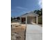New construction, one story home with an orange front door and covered parking area at 629 W 9Th, Lakeland, FL 33805