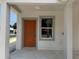 Covered porch with orange front door and large window, columns and concrete patio at 629 W 9Th, Lakeland, FL 33805
