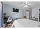 Well-lit bedroom with a ceiling fan, tv, desk, and a white comforter on the bed at 647 Hart Lake Dr, Winter Haven, FL 33884