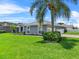 A palm tree and manicured garden add a touch of paradise to this home, enhancing its curb appeal at 647 Hart Lake Dr, Winter Haven, FL 33884
