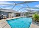 Sparkling pool with waterfall feature surrounded by a screened enclosure and ample patio space for outdoor entertaining at 647 Hart Lake Dr, Winter Haven, FL 33884
