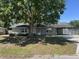 Charming single-story home featuring a covered carport and a large shade tree in the front yard at 6610 Chippendale Rd, Lakeland, FL 33809