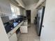 Galley-style kitchen featuring black countertops, stainless steel appliances, and tile flooring at 6610 Chippendale Rd, Lakeland, FL 33809