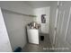 Compact laundry area features a washer, wall shelving, and electrical panel at 6610 Chippendale Rd, Lakeland, FL 33809