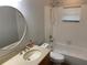 Bright bathroom features a round mirror, tan granite countertop and a shower-tub combination at 676 Jessanda Cir, Lakeland, FL 33813