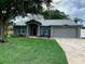 Charming single-story home with a well-maintained lawn, attached two-car garage, and mature trees at 676 Jessanda Cir, Lakeland, FL 33813