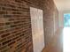 Hallway features brick accent wall and white closet doors, leading to a bright living space at 676 Jessanda Cir, Lakeland, FL 33813