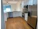 Kitchen with hardwood floors, white cabinets, stainless steel appliances, and view to an outdoor patio at 676 Jessanda Cir, Lakeland, FL 33813