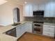 Modern kitchen with white cabinets, stainless steel appliances, quartz countertops and hardwood floors at 676 Jessanda Cir, Lakeland, FL 33813