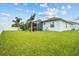Expansive backyard with manicured lawn, screened lanai, and white fence, ideal for outdoor enjoyment at 6777 Bentridge Dr, Lakeland, FL 33813