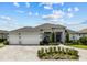 Beautiful single-story home boasts a three-car garage, manicured landscaping, and a stone-accented entryway at 6777 Bentridge Dr, Lakeland, FL 33813