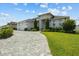 Charming single-story home featuring a three-car garage, manicured lawn, and a stone-accented facade at 6777 Bentridge Dr, Lakeland, FL 33813