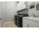 Well-equipped laundry room with modern washer and dryer, sink, and white cabinets for ample storage at 6777 Bentridge Dr, Lakeland, FL 33813
