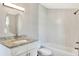 Modern bathroom with gray walls, granite vanity, new mirror, and tiled shower and tub at 6949 2Nd St, Mulberry, FL 33860