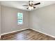 Comfortable bedroom featuring light gray walls, ceiling fan, natural light, and wood-look flooring at 6949 2Nd St, Mulberry, FL 33860