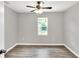 Neutral bedroom features hardwood floors, ceiling fan, and natural light from the window at 6949 2Nd St, Mulberry, FL 33860