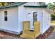 Cozy home entrance with a wooden step-up deck, white siding, and clearly marked house numbers at 6949 2Nd St, Mulberry, FL 33860