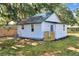 Charming cottage-style home featuring a green metal roof and white siding, surrounded by mature trees and a well-maintained yard at 6949 2Nd St, Mulberry, FL 33860