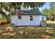 The exterior of the house features white siding, a green metal roof covered in leaves, and a well-kept lawn at 6949 2Nd St, Mulberry, FL 33860