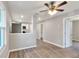 Inviting living room showcasing durable wood-look floors, a ceiling fan, and an open layout to the kitchen at 6949 2Nd St, Mulberry, FL 33860