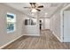 Bright and airy living room with light gray walls, stylish ceiling fan, and durable wood-look floors at 6949 2Nd St, Mulberry, FL 33860