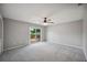 Spacious bedroom featuring neutral walls, carpeting, and sliding glass doors leading to the wooden deck at 707 Laurel Pointe Ct, Lakeland, FL 33813