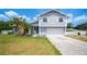 Charming two-story home featuring light-gray siding, a stone chimney, and lush palm trees in the front yard at 707 Laurel Pointe Ct, Lakeland, FL 33813