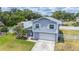 Two-story home with gray siding, white trim, attached garage, palm trees, and landscaped front yard at 707 Laurel Pointe Ct, Lakeland, FL 33813